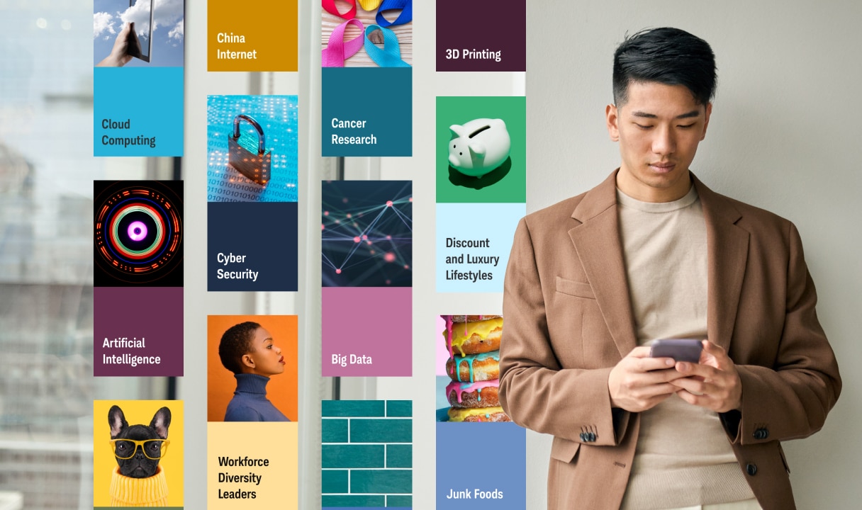 Man looking at cell phone standing next to a wall with various investing theme tiles.